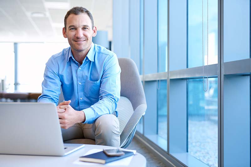 staffing solutions agency massachusetts: smiling man at work on a laptop